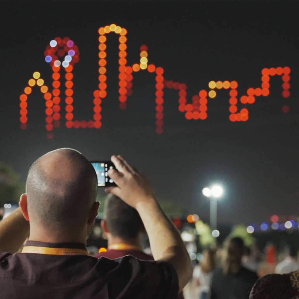 Man photographing illuminated festival decorations at night
