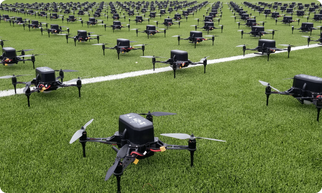 Numerous drones positioned orderly on green turf