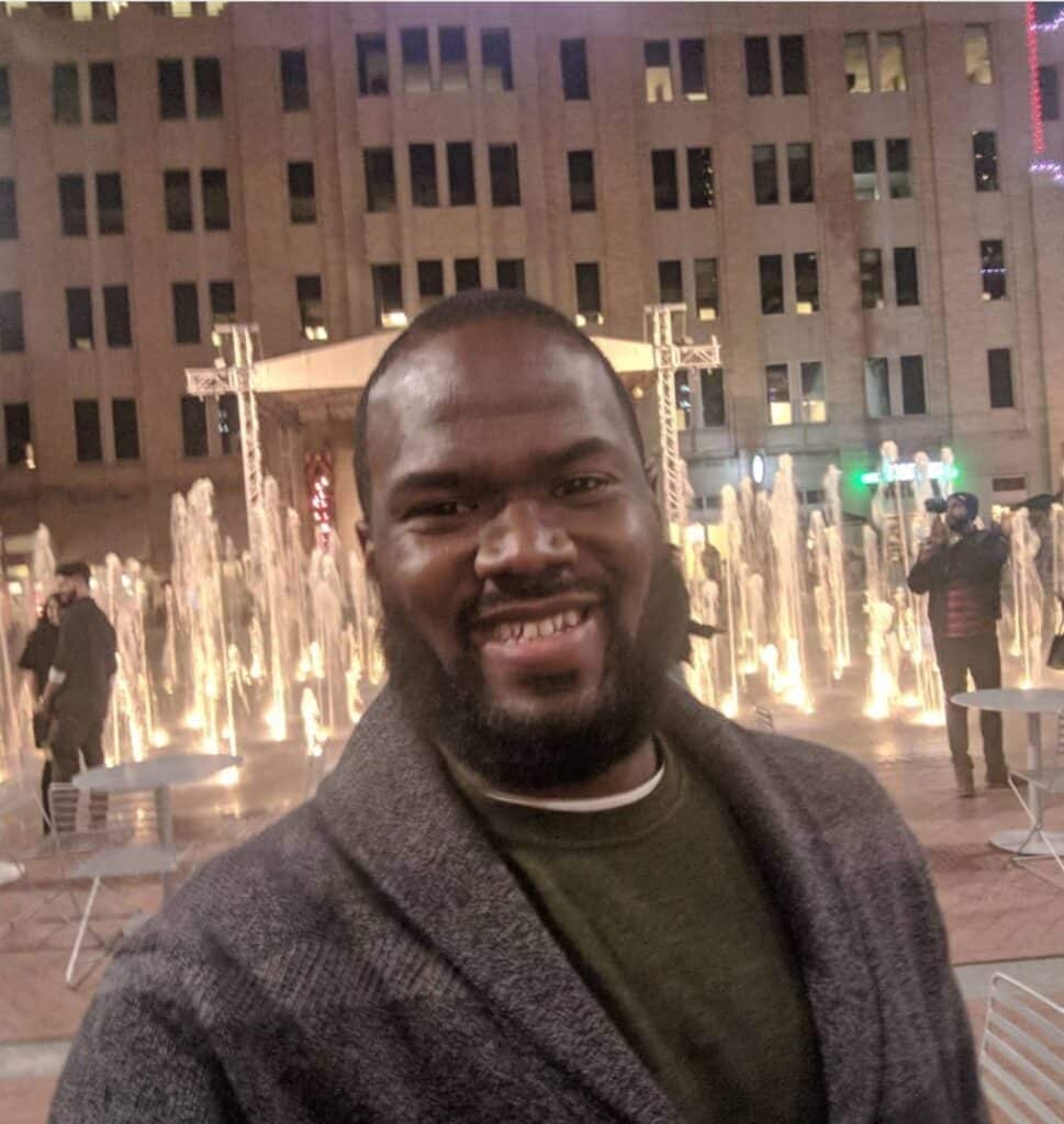 Smiling man at night with festive city lights