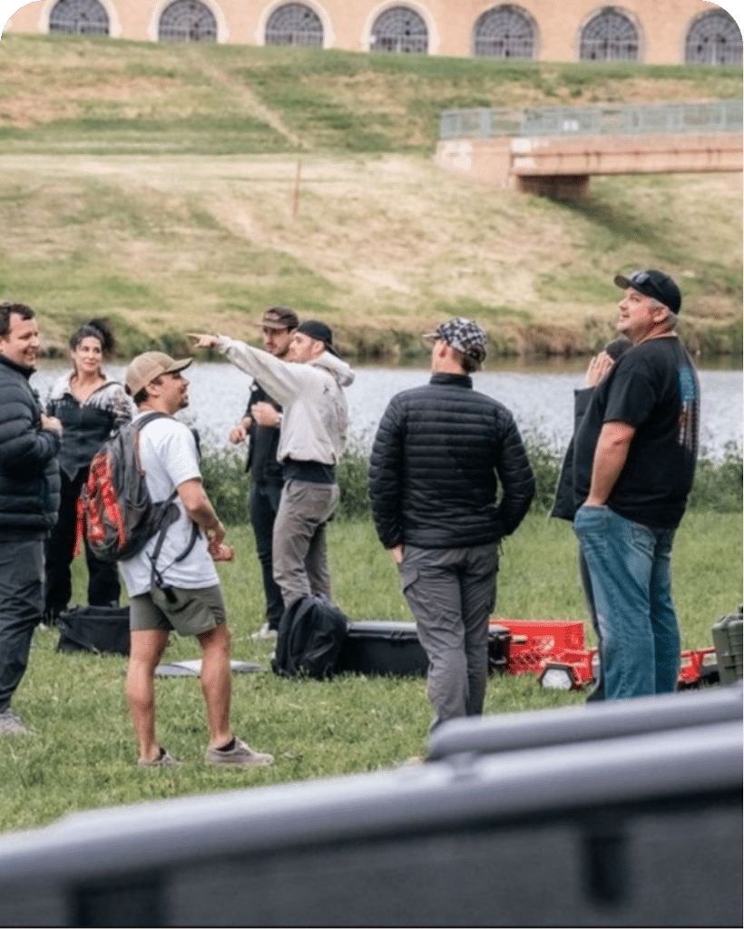 Group of people discussing near river, outdoor setting