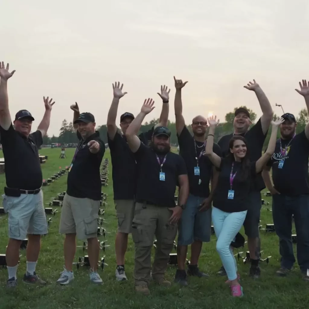 Joyful event staff waving arms at outdoor venue